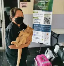  ?? ?? An owner carries her cat to be neutered.