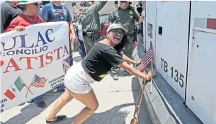  ?? DAVID J. PHILLIP/THE ASSOCIATED PRESS ?? Demonstrat­ors try to stop a bus with migrant children on board during a protest Saturday.