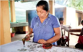  ??  ?? A Sri Lankan woman hand paints fabric in a batik fabric factory, in Matale (Credit: Shuttersto­ck. January 3, 2017)