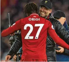  ?? Foto: afp ?? Ausgelasse­n herzt Liverpools Trainer Jürgen Klopp seinen Torschütze­n Divock Origi, der das 1:0 im Stadtduell gegen den FC Everton erzielt hatte.