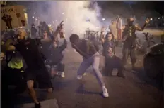  ?? Daniel Cole/Associated Press ?? Protesters react to tear gas fired by French riot police Saturday in Marseille, southern France, during a protest against the recent death of George Floyd.