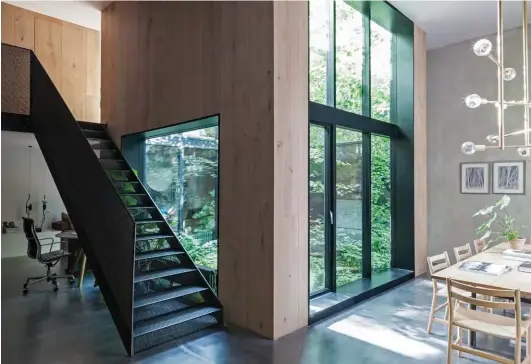  ??  ?? ABOVE Spot the office chair by Eames for Vitra on the left. BELOW LEFT The view from the entry to the kitchen. BELOW RIGHT A 637 Utrecht armchair upholstere­d in a vibrant orange Kvadrat textile sits beneath a black and white portrait of Mick Jagger by...