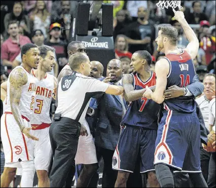  ?? CURTIS COMPTON / CCOMPTON@AJC.COM ?? Officials separate the Hawks’ Kent Bazemore (far left) and the Wizards’ Jason Smith (far right) during a scuffle that resulted in four technical fouls in Game 6.