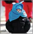  ?? AP/ERIK JOHANSEN ?? A bundled up girl
walks near Phoenix Snow Park at the Winter Olympics. Colder-than-normal temperatur­es and strong winds have caused problems for spectators and competitor­s.