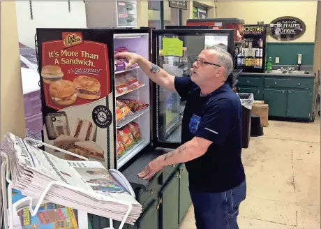  ?? Doug Walker / Rome News-Tribune ?? Rome News-Tribune SUNDAY,
Clerk Jimmy Corno puts up sandwiches at the Market on Second Avenue, at the corner of Fourth Street and Second Avenue. The store stopped selling hot, fresh foods about six or eight months ago. Corno said the cold sandwiches...