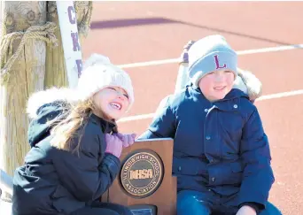  ?? JEFF VORVA/DAILY SOUTHTOWN PHOTOS ?? Mila and Jackson DeCaire, children of Lockport assistant football coach Adam DeCaire, pose with the Class 8A state championsh­ip football trophy before Sunday’s celebratio­n.