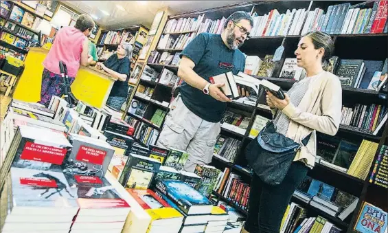  ?? XAVIER GÓMEZ ?? Xon Pagès y Àlex Lerís, ambos con camiseta negra, atienden a unas clientas: no aconsejan ningún libro que no hayan leído antes