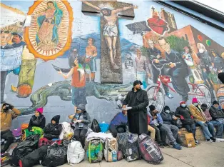  ?? ASSOCIATED PRESS FILE PHOTO ?? Migrants eat and wait for assistance in 2022 while camping on a street in downtown El Paso. Christian voters and faith leaders have long been on the frontlines of providing assistance to migrants, but when it comes to support for immigratio­n policies, views diverge broadly.