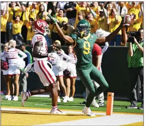  ?? (AP/Waco Tribune-Herald/Ernesto Garcia) ?? Baylor wide receiver Tyquan Thornton (9) celebrates his touchdown in front of Oklahoma defensive back Key Lawrence on Saturday during the No. 13 Bears’ 27-14 victory over the No. 8 Sooners in Waco, Texas. Baylor’s victory ended Oklahoma’s 17-game winning streak.