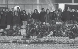  ?? MAXIM SHEMETOV/REUTERS ?? People hold a candleligh­t vigil at the Crocus City Hall concert venue outside Moscow on Sunday. Russia’s capital city declared Sunday a day of mourning over Friday night’s shooting.