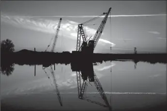  ?? GARY CORONADO/LOS ANGELES TIMES ?? Dredging cranes rise over a section of the Sacramento-San Joaquin River Delta in Isleton.