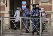  ?? DMITRI LOVETSKY — THE ASSOCIATED PRESS ?? Russian Rosguardia (National Guard) servicemen stand watch at a polling station during the presidenti­al elections in St. Petersburg, Russia, Saturday.