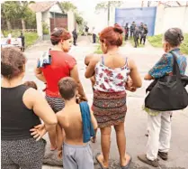  ??  ?? CURIOSOS OBSERVAN LA ESCENA DONDE AYER FUE ASESINADA UNA PAREJA EN AGUILARES. LA POLICÍA APUNTA A LA PANDILLA DE LA ZONA COMO RESPONSABL­E.