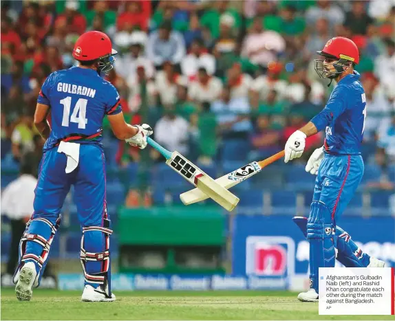  ?? AP ?? Afghanista­n’s Gulbadin Naib (left) and Rashid Khan congratula­te each other during the match against Bangladesh.