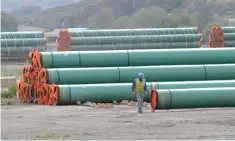  ?? — Reuters photo ?? A workman walks past steel pipe to be used in the oil pipeline constructi­on of Kinder Morgan Canada’s Trans Mountain Expansion Project at a stockpile site in Kamloops, British Columbia.