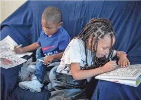  ?? ?? Kendric, left, and Saniyah keep themselves busy and entertaine­d in the family’s Lake Worth Beach apartment.