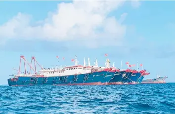  ?? PHILIPPINE COAST GUARD ?? Chinese vessels are anchored last month at Whitsun Reef, a boomerang-shaped feature that emerges above water only at low tide. At one point in March, more than 200 Chinese ships were reported anchored around the reef.