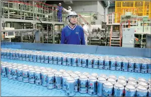  ?? AP/KOJI SASAHARA ?? Asahi Breweries plant manager Shinichi Uno watches the production line at an Asahi Breweries factory in Moriya near Tokyo in late May.