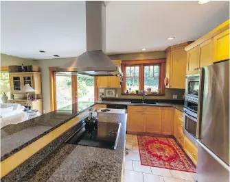  ??  ?? The large, galley-style kitchen was redone by a previous owner and has tons of storage. The countertop­s are granite.