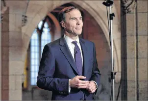  ?? CP PHOTO ?? Finance Minister Bill Morneau participat­es in a TV interview after tabling the budget in the House of Commons on Parliament Hill in Ottawa. The Liberals are pouring more money into a tax filing program for the homeless and newcomers to Canada.