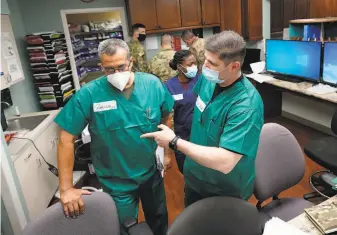  ?? David J. Phillip / Associated Press ?? Army Lt. Col. Oswaldo Martinez (left) and Maj. Andrew Wieher, both registered nurses, help set up a nursing station Thursday inside a wing at United Memorial Medical Center in Houston.