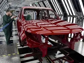  ?? PHOTO: ?? Workers check the paintwork on Range Rover bodies at Jaguar Land Rover’s factory in Solihull, Britain.