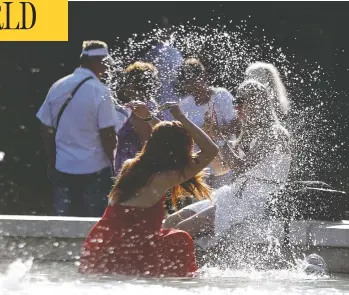  ?? LUCA BRUNO/THE ASSOCIATED PRESS ?? A woman escapes the heat by cooling off in a public fountain in front of the Sforza Castle in Milan, Italy, on Friday.