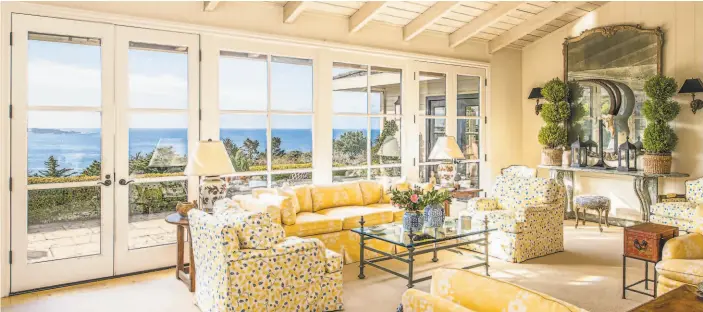  ?? Ron Bird Photograph­y ?? Above: The living room at 1675 Crespi Lane in Pebble Beach features a vaulted, beamed ceiling and French doors opening to a patio overlookin­g the ocean. Below: The Pebble Beach home features verdant gardens and views of the water.