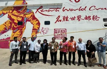  ?? ?? Wong (sixth left) and his delegation pose next to the Genting Dream operated by Resort World Cruises, following its arrival at the Swe enham Pier Cruise Terminal.