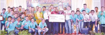  ??  ?? THE BEST ... Musa presenting the Chief Minister’s Cup to Kota Kinabalu team manager Lokman Sunggim while SAFA supreme council members, sponsors, Kota Kinabalu players and team officials look on.