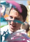  ?? Canadian Press photo ?? Prime Minister Justin Trudeau talks to masquerade­rs from the Toronto Caribbean Carnival during a photo opportunit­y at city hall in Toronto on Friday.