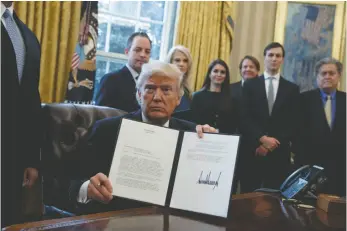  ?? AP PHOTO ?? President Donald Trump shows his signature on an executive order on the Keystone XL pipeline on Jan. 24 in the Oval Office of the White House.