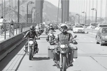  ?? Associated Press ?? ABOVE:
In this July 2016 photo provided by Alisa Clickenger, Clickenger leads a group of female riders over the Golden Gate Bridge in San Francisco at the end of a cross-country trip to honor two sisters from Brooklyn, N.Y., who made a similar ride in...