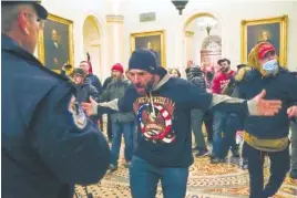  ?? AP FILE PHOTO/MANUEL BALCE CENETA ?? Supporters of President Donald Trump, including Doug Jensen, center, confront U.S. Capitol Police in the hallway outside of the Senate chamber at the U.S. Capitol in Washington.