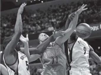  ??  ?? Nuggets center Joffrey Lauvergne tries to get off a shot between the Grizzlies’ Zach Randolph, left, and Tony Allen in the first half Friday night inMemphis. Brandon Dill, The Associated Press ,