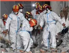  ?? ?? Rescue workers evacuate the 10th survivor pulled alive after being trapped 132 hours