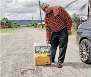  ?? ?? RIGHT: Raj Maharaj, of Acaciavill­e, has filled the potholes on the street where he lives.