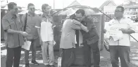  ??  ?? PENDUDUK Kampung Keramat ‘memeluk’ Michael sebagai tanda penghargaa­n terhadap pemberian bantuan tangki 1Malaysia.