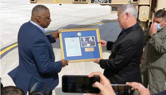  ??  ?? U.S. Defense Secretary Lloyd Austin, left, presents Israeli Defense Minister Benny Gantz, right, with a framed copy of a formerly Top Secret memo regarding U.S. considerat­ion of granting official recognitio­n of the state of Israel shortly after its creation in 1948, at Nevatim Israeli Air Force Base, yesterday in Israel. The inset photo on right shows President Truman and Secretary of State George Marshall. Photo: AP