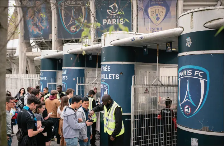  ?? PHOTOS BY DMITRY KOSTYUKOV / THE NEW YORK TIMES ?? Soccer fans enter Stade Charléty stadium for a Paris FC home game April 6 against Grenoble in Paris. Last November, Paris FC became home to an unlikely revolution by announcing that it was doing away with ticket prices for the rest of the season.