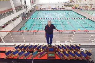  ?? ADOLPHE PIERRE-LOUIS/JOURNAL ?? In this 2015 photo, Dave Barney poses with some of the blue trophies Albuquerqu­e Academy’s swim program has earned for winning state championsh­ips under his leadership.