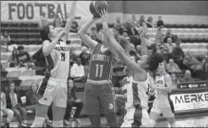  ?? Courtesy Photo ?? Caitlyn Corley, No. 11, sends a shot to the net through two Merkel defenders during the Coahoma/merkel district game held on Tuesday, Dec. 17, 2019.