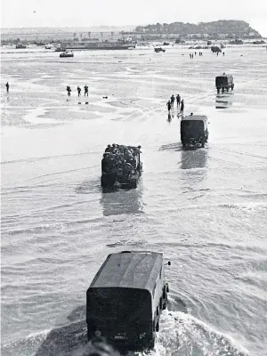  ?? Getty. ?? Left: Landing craft approachin­g the French coast with the first wave of troops. Above: Allied vehicles disembark on to the beaches.