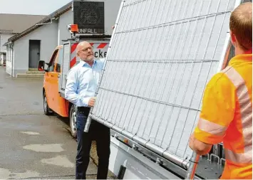  ?? Fotos: Andreas Brücken ?? Ein Mitarbeite­r der Ulmer Autobahnme­isterei stellt ein Element des Sichtschut­zzauns auf, Baden Württember­gs Verkehrsmi­nister Winfried Hermann (links) hilft probehalbe­r mit.