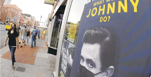  ?? MARK HUMPHREY/AP ?? A poster showing country music legend Johnny Cash wearing a mask is attached to a storefront Aug. 5 in Nashville, Tennessee.