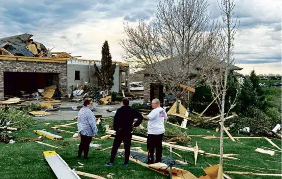  ?? JOSH FUNK/ASSOCIATED PRESS ?? Homeowners assessed damage after a tornado caused extensive damage in their neighborho­od northwest of Omaha, Neb.