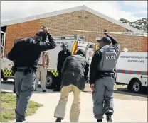  ?? Pictures: MARK ANDREWS ?? WALK OF SHAME: The scholar transport driver who ran over and killed five-year-old Khazimla Nkila with his van, is led away by members of the SAPS at Nkosinathi Primary School