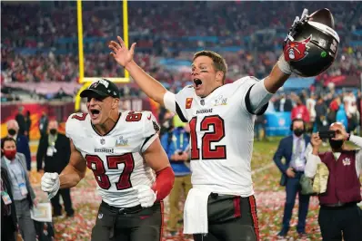  ?? The Associated Press ?? Tampa Bay Buccaneers tight end Rob Gronkowski, left, and quarterbac­k Tom Brady (12) celebrate after Super Bowl 55 against the Kansas City Chiefs in Tampa, Fla., on Feb. 7. Brady’s fifth Super Bowl title, at 43 no less, was one of the best moments of 2021, when a continuing pandemic could not dim the brightest of stars of the sports world.