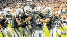  ?? L.E. Baskow Las Vegas Review-journal @Left_eye_images ?? Raiders players celebrate after their “Monday Night Football” overtime win against the Baltimore Ravens at Allegiant Stadium.