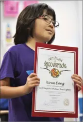  ?? Tammy Murga/The Signal ?? Kiran Dong, 7, holds his certificat­e of recognitio­n after being selected to light the Capitol Christmas tree with Gov. Brown.